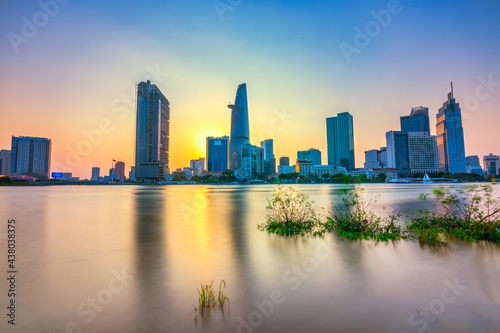 Riverside city sunset moments in the sky at end of day brighter coal sparkling skyscrapers along beautiful river in Ho Chi Minh City  Vietnam