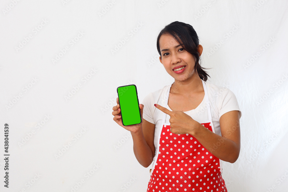 Portrait of asian woman wearing kitchen apron while showing a blank cell phone. Isolated on white background Portrait of asian woman wearing kitchen apron while showing a blank cell phone. Isolated on white background