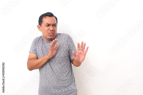Asian man with disgusted expression repulsing something. Disgust concept. Emotional man. Human emotions, facial expression concept. Isolated on white background