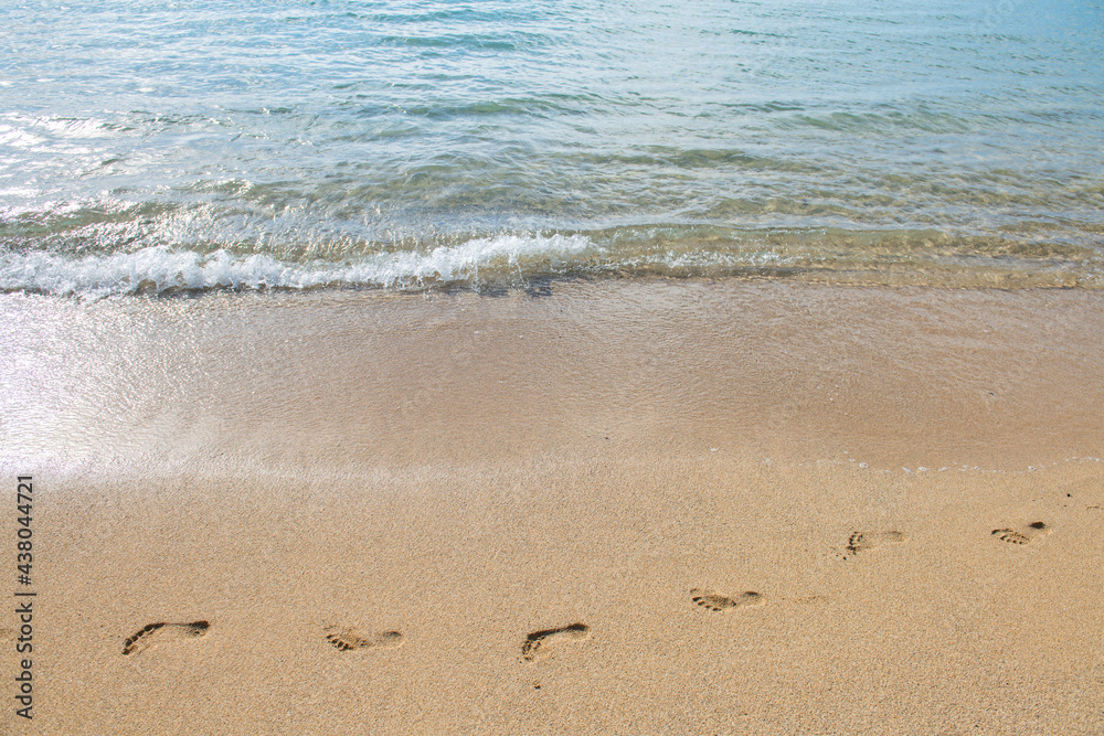 Sandy summer beach, wave and footprints at sunset time. Sandy summer beach, wave and footprints at sunset time.