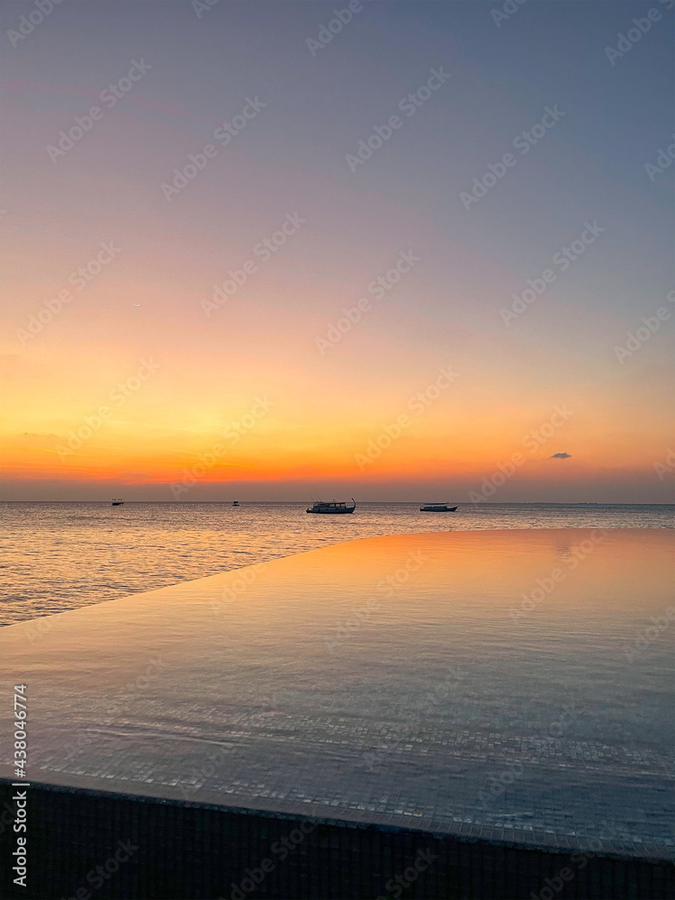 Wide panoramic landscape of stunning sunset over Indian Ocean on Maldives island. Exotic tropical island beach background. 