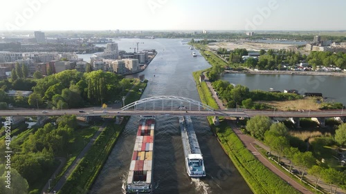 Aerial drone view of two freight ships passing under a bridge on the Amsterdam Rijnkanaal in Amsterdam, The Netherlands. photo