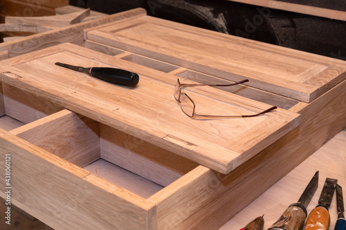 Production of custom-made furniture. Glasses and a screwdriver on the cabinet are handmade from natural wood in light colors. Selective Focus