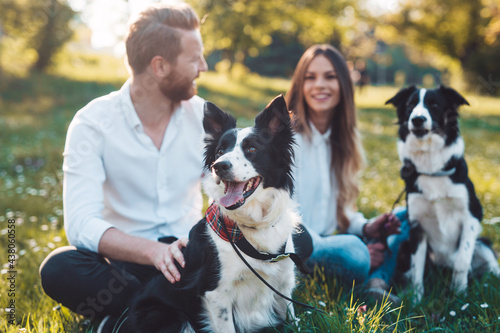 Photography Happy young couple walking, playing with dogs in a park