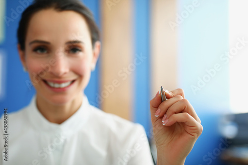 Business woman holding silver ballpoint pen closeup