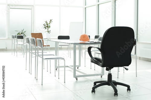 Flipchart construction helmet chairs glass table in office space