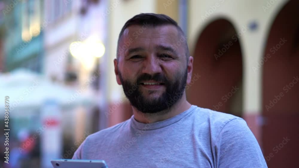 Portrait of happy, handsome man with tablet sitting at cafe in city Portrait of happy, handsome man with tablet sitting at cafe in city