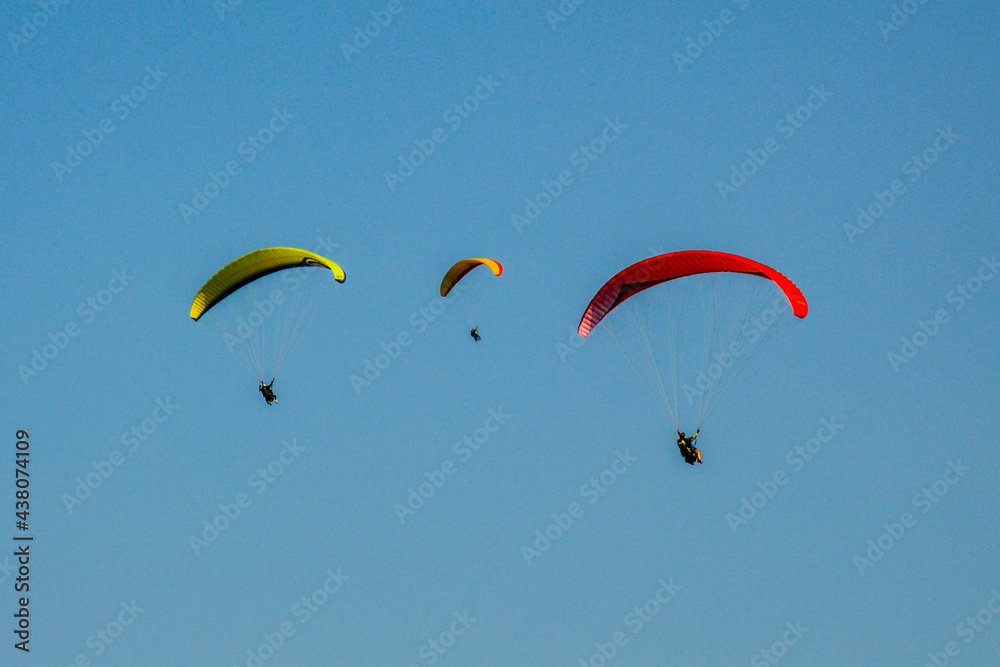 Three paragliders flying high in the blue sky Three paragliders flying high in the blue sky