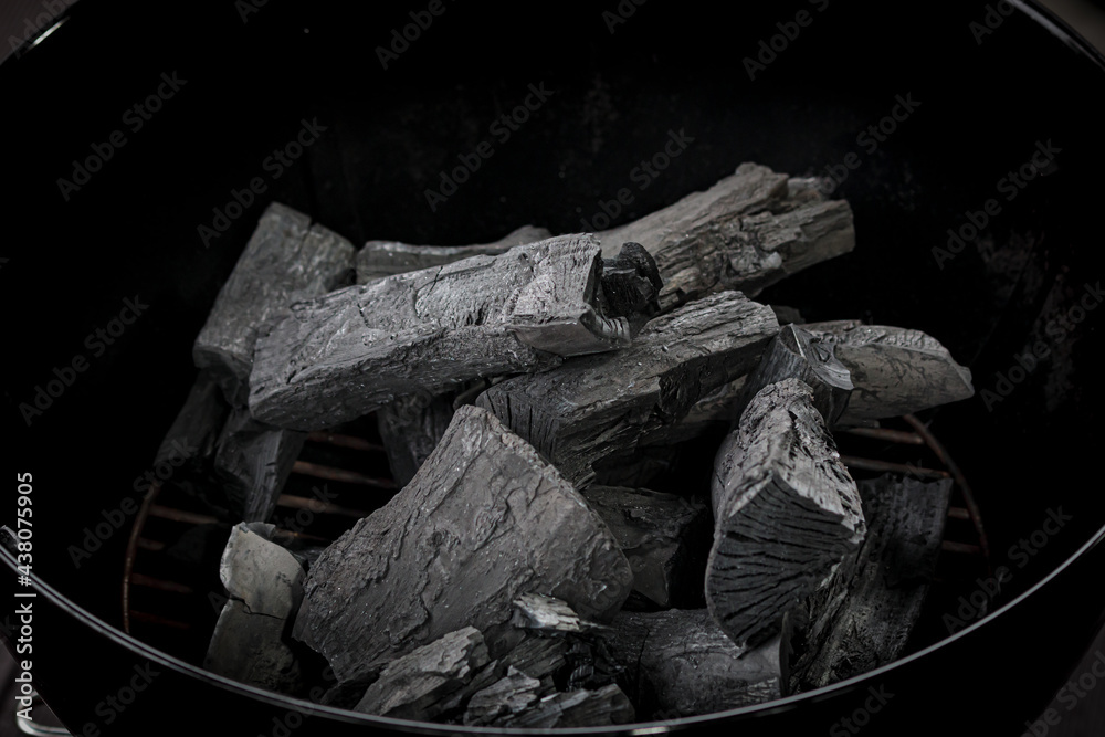 Grill charcoal. BBq coal texture. Barbeque charcoal in brazier, top view. Organic hardwood timber coal, activated fossil carbon, natural ignition for picnic cooking