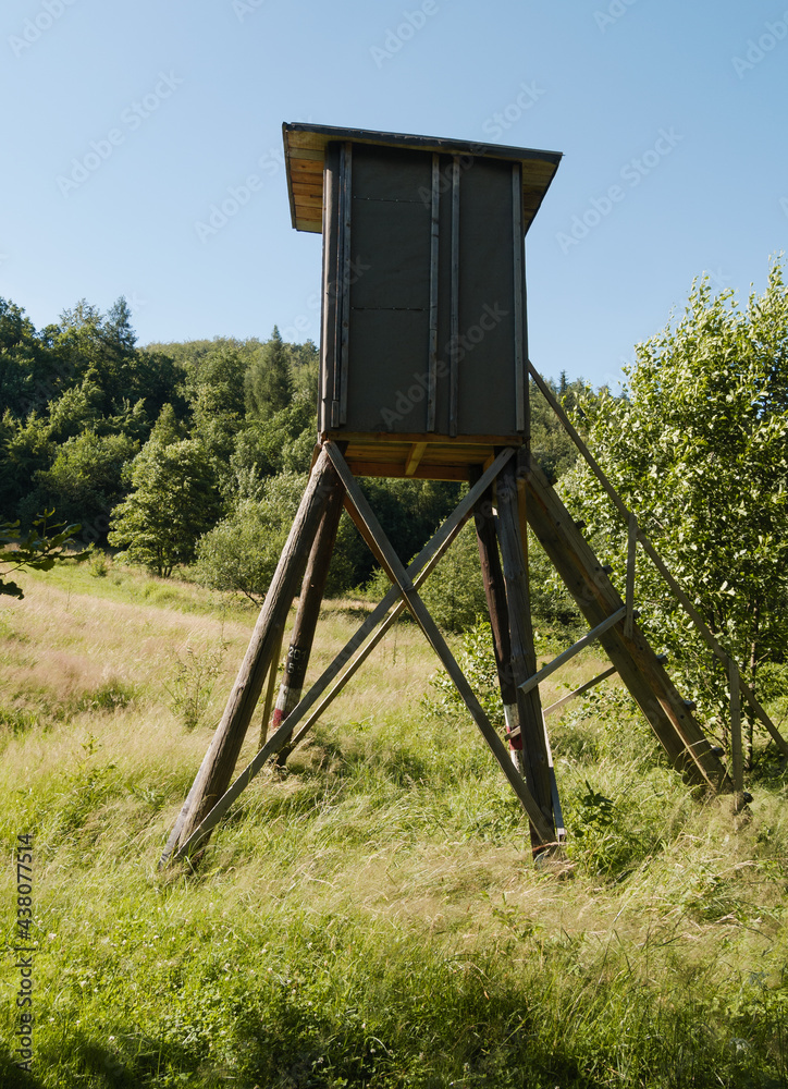 Naklejka premium Wooden observation and hunting tower booth in a forest.
