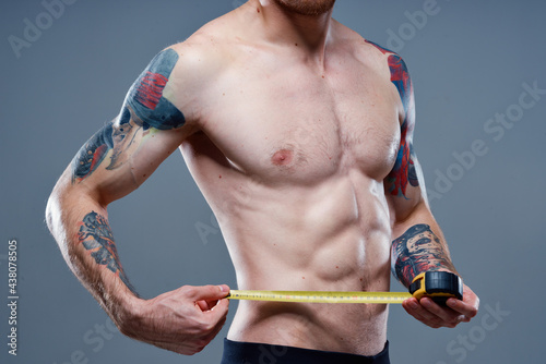 athlete pumped up arm muscles and tattoos bodybuilder fitness tape measure sports