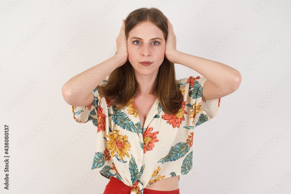 Woman plugging ears with hands does not wanting to listen hard rock or loud music. European Young female ignoring noise or din covering her ears with hands avoiding loud sounds at street. Woman plugging ears with hands does not wanting to listen hard rock or loud music. European Young female ignoring noise or din covering her ears with hands avoiding loud sounds at street.
