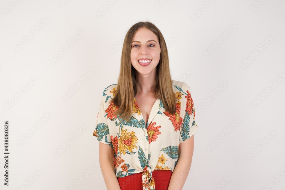 Beautiful Young caucasian woman with happy and funny face smiling and showing tongue. Wearing casual clothes and standing against gray studio background. Beautiful Young caucasian woman with happy and funny face smiling and showing tongue. Wearing casual clothes and standing against gray studio background.