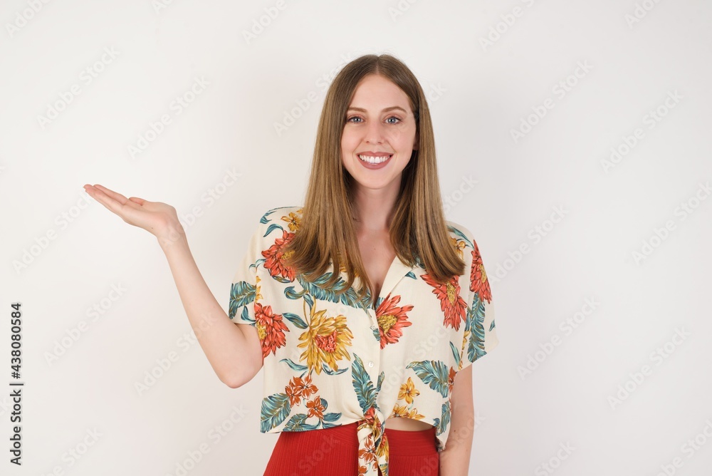 Positive glad female says: wow how exciting it is, has amazed expression, shows something on blank space with open hand over isolated background. Advertisement concept. Positive glad female says: wow how exciting it is, has amazed expression, shows something on blank space with open hand over isolated background. Advertisement concept.