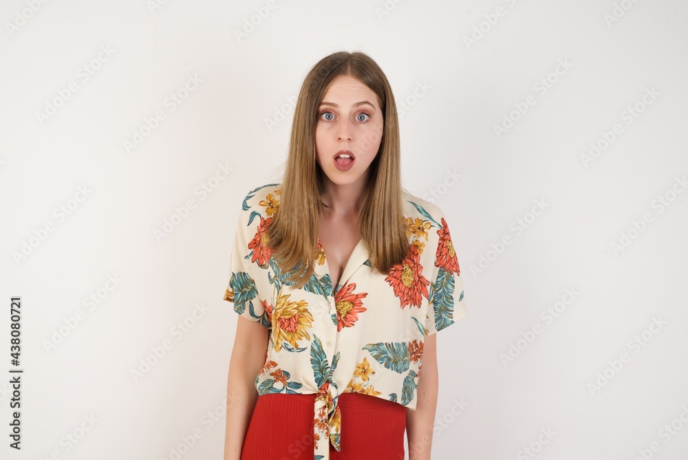 Emotional attractive blonde female with opened mouth expresses great surprisment and frighteness, poses against white background, stares at camera. Unexpected shocking news and human reaction.