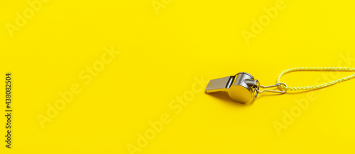 Sports whistle on yellow background. Concept- sport competition, referee, statistics, challenge. Basketball, handball, futsal, volleyball, soccer, baseball, football and hockey referee whistle photo