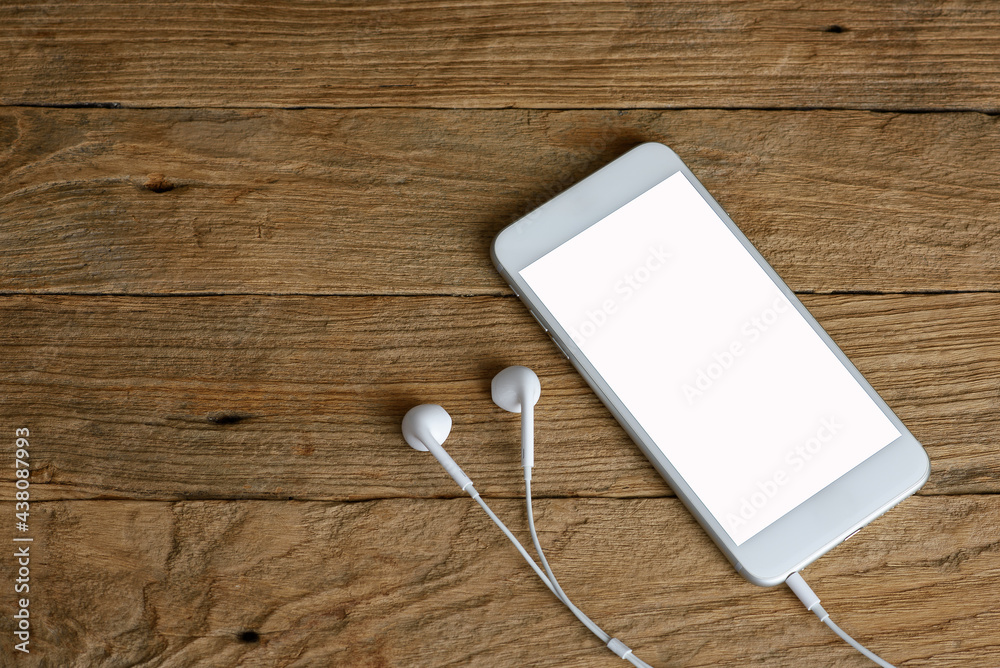 Top view of wooden desk with smartphone, earphone and copy space Top view of wooden desk with smartphone, earphone and copy space