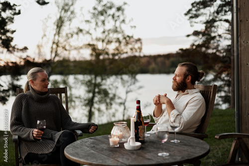 Couple sitting on porch and drinking wine photo