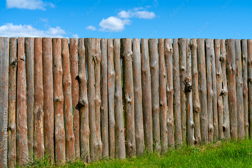 Fototapeta premium Log wooden fence. The texture of the old wooden fence. Wooden vintage background.