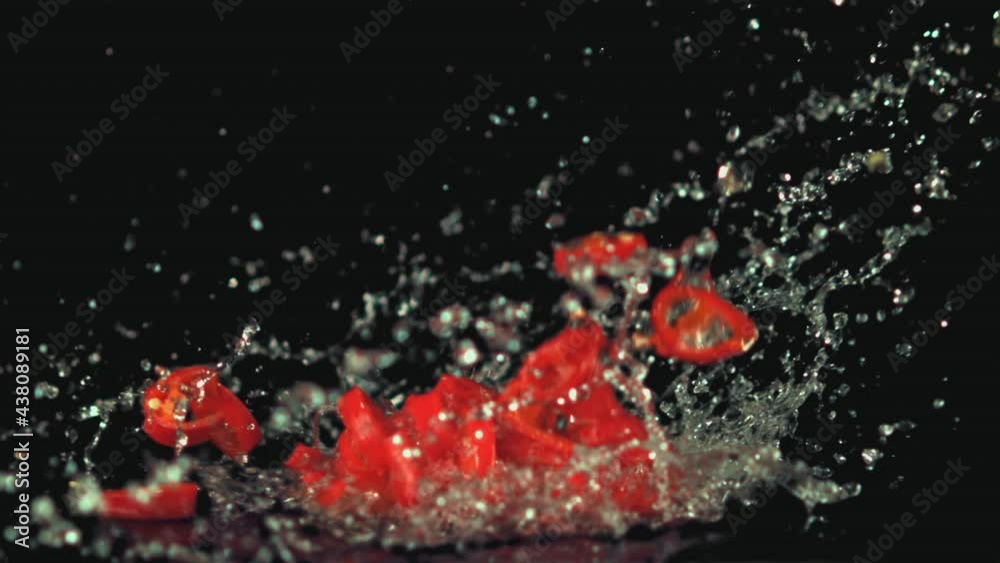 Super slow motion chopped chilli pepper falls on the water with splashes. On a black background. Filmed on a high-speed camera at 1000 fps. High quality FullHD footage Super slow motion chopped chilli pepper falls on the water with splashes. On a black background. Filmed on a high-speed camera at 1000 fps. High quality FullHD footage