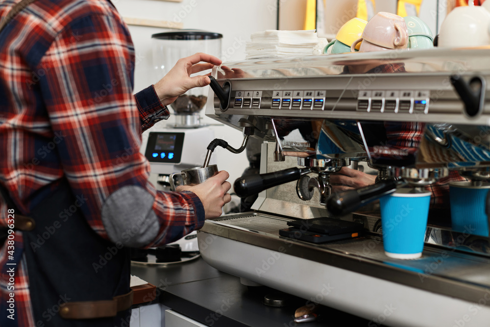 barista in apron pours fresh coffee into a cup barista in apron pours fresh coffee into a cup