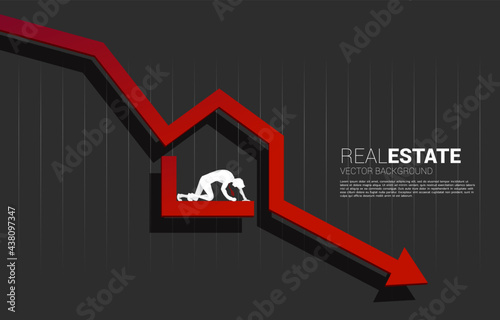 silhouette of businessman falling in home icon in falling down arrow. Concept of decline in real estate business and properties price