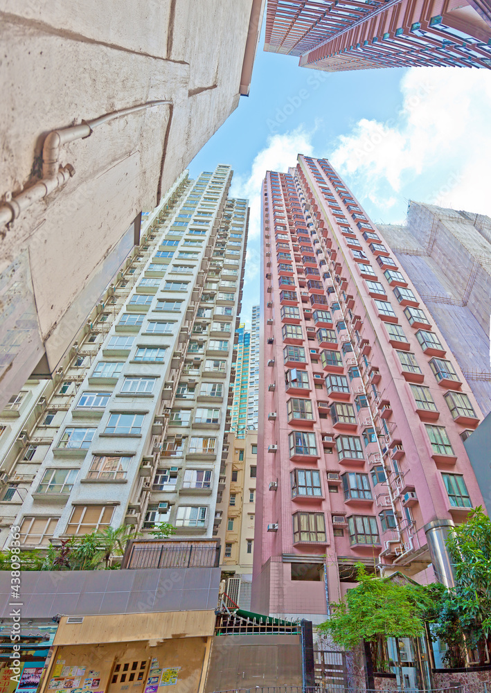 Naklejka premium Vertical view up along skyscraper facades from a narrow street in Hong Kong