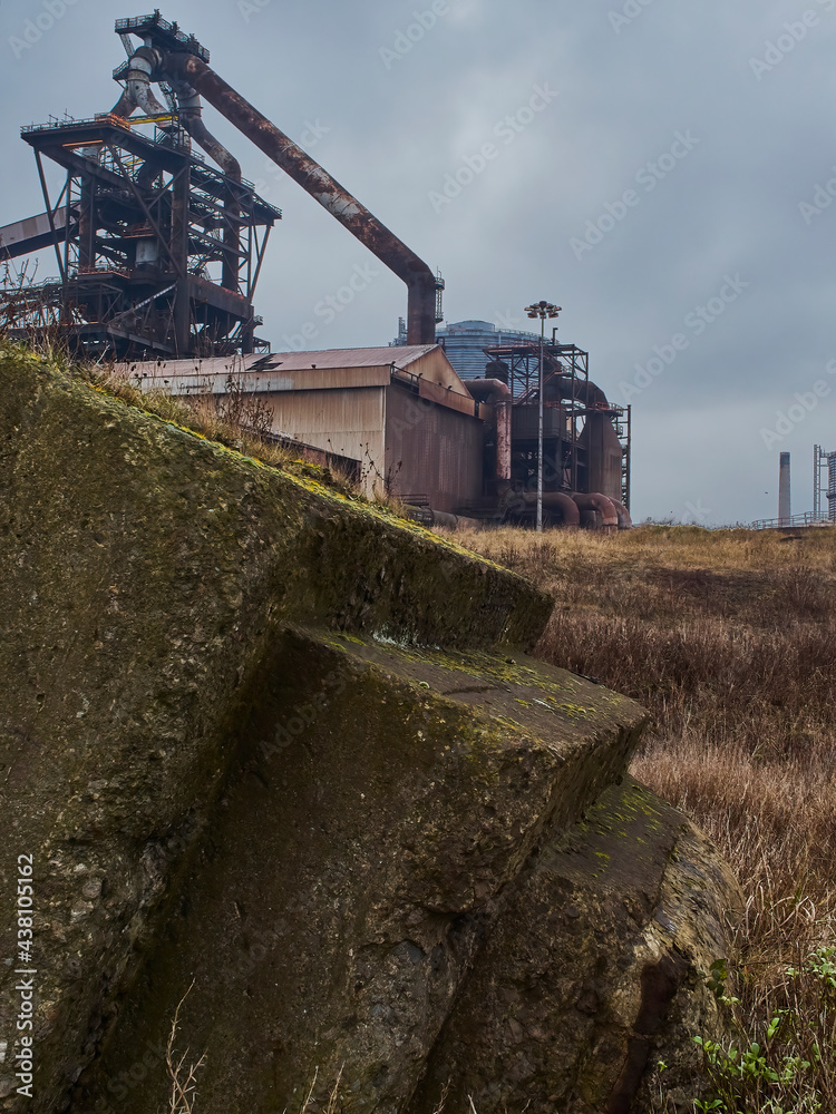 A detail from the abandoned Redcar Steelworks complex, showing the intricate web of support structure for the blast furnace and a rusting workshop.