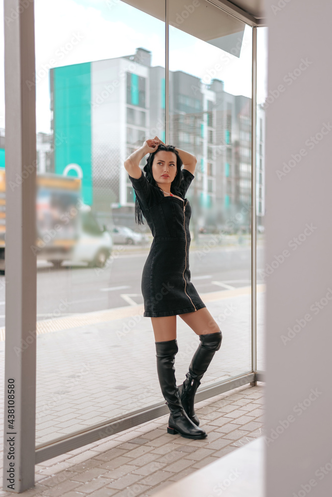 Beautiful young woman in dress posing at the bus stop with good weather Beautiful young woman in dress posing at the bus stop with good weather