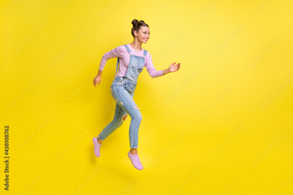 Profile photo of fast lady jump run look empty space wear denim overall shoes isolated yellow background