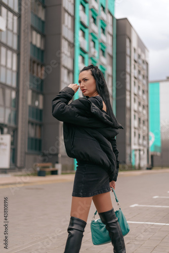 Beautiful brunette young woman in dress and posing on the street © Katusya