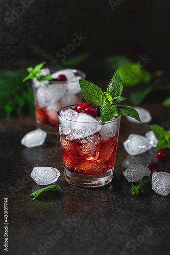 Berry alcoholic cocktail liqueur, vodka, ice and mint. Refreshing cool drink, berry liqueur or red alcoholic cocktail.