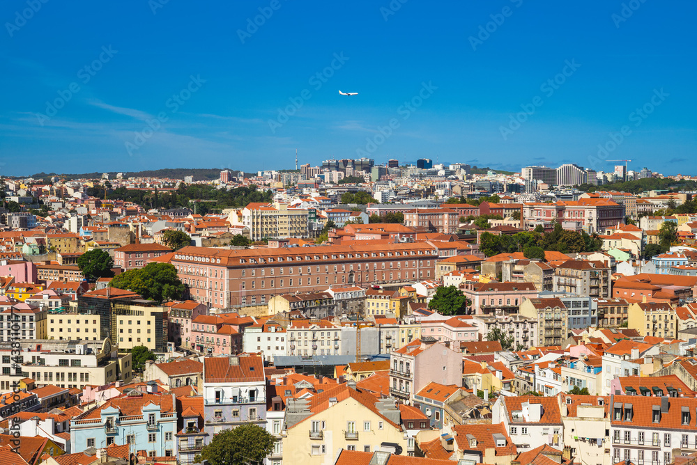 An airplane fly over lisbon, the capital city of portugal