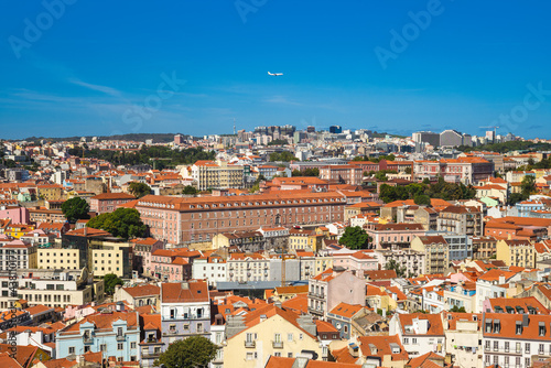 An airplane fly over lisbon, the capital city of portugal