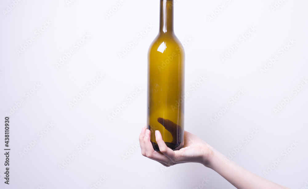 a woman's hand holding a glass bottle