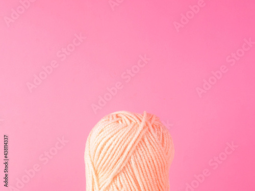 Spool of yarn on pink background