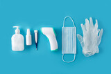 Medical gloves,disinfectant, thermometer, hand sanitizer and surgical mask on blue background