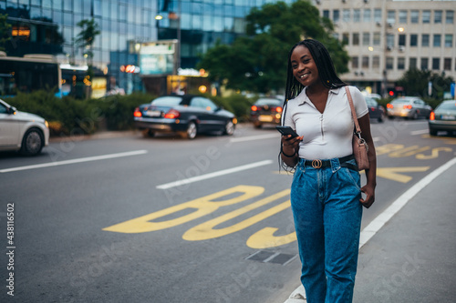 Cheerful african american woman using smartphone while on the bus stop © Zamrznuti tonovi