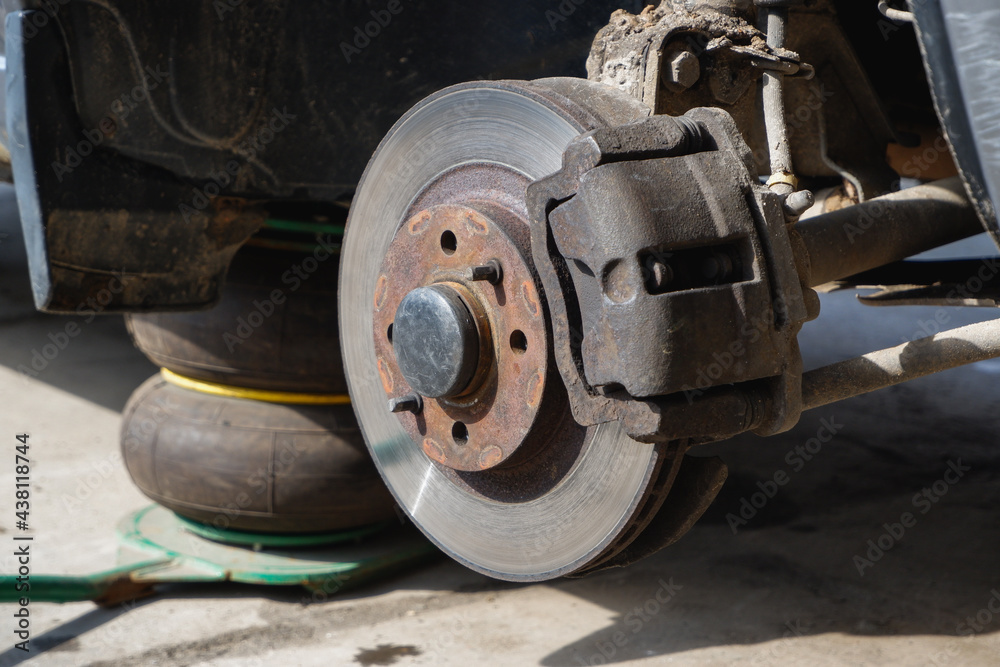 Car repair. Car with removed wheels on pneumatic jacks. View of the brake discs hub. Car repair. Car with removed wheels on pneumatic jacks. View of the brake discs hub.