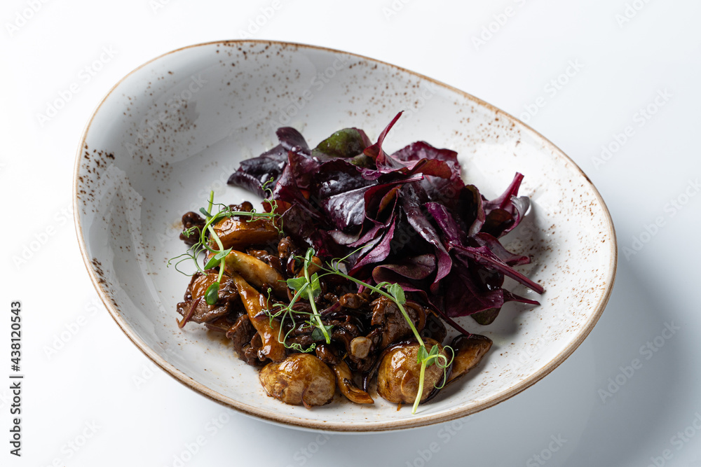 Sauteed button mushrooms with salad leaves,  isolated on white studio background, top view