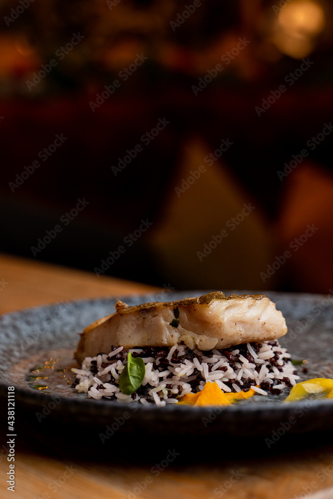 Gourmet roasted fish with wild rice, restaurant photo