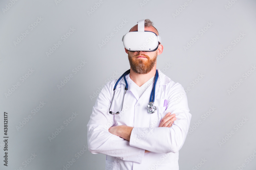 Handsome male doctor on gray background in virtual reality glasses Handsome male doctor on gray background in virtual reality glasses