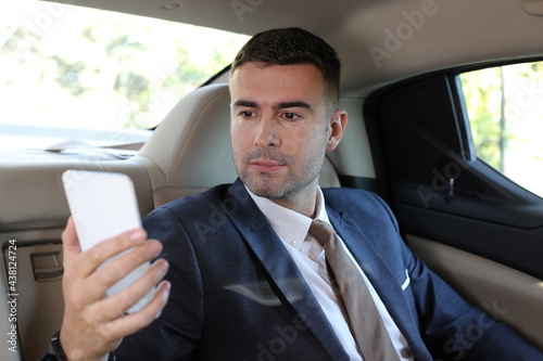 Elegant car passenger using phone  © ajr_images