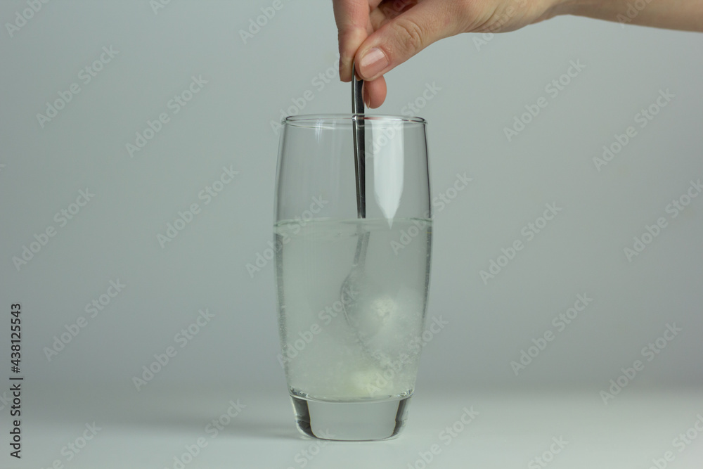 Closeup of myo-inositol powder dissolved in a glass of water.