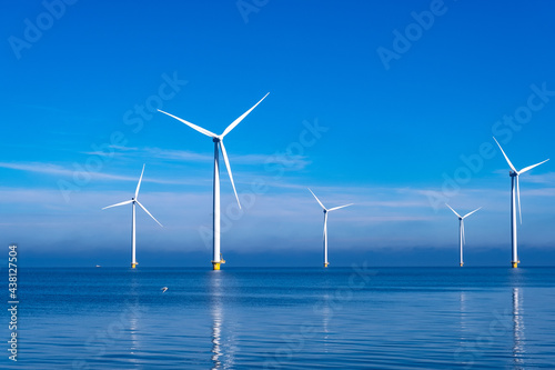 offshore windmill park with clouds and a blue sky, windmill park in the ocean aerial view with wind turbine Flevoland Netherlands Ijsselmeer. Green energy  photo