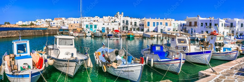 Greece travel. Cyclades, Paros island. Charming fishing village Naoussa. view of old port with  boats and street taverns by the sea. may 2021