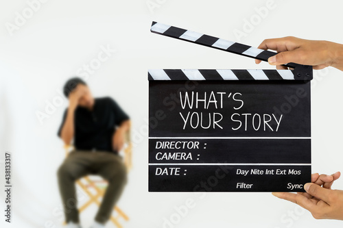 what's your story.title text on film slate and stressed man on a chair photo