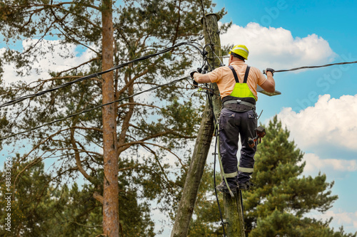 Canvastavla electrical lineman connecting wires high on electric pole