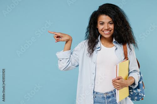 фотографія Young fun african american girl teen student in denim clothes backpack hold book