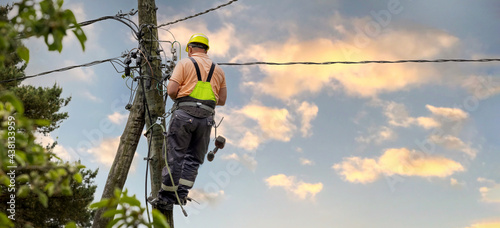 electrical lineman working on electric pole. electrician at work. banner copy space photo